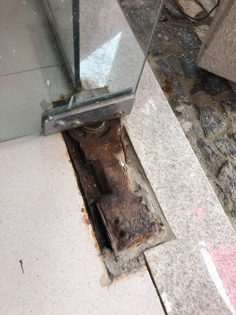 Bisagra de piso común oxidada